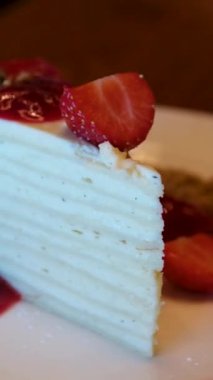 Beyaz pasta, ince pastalar, üzerinde çilek reçeli olan katmanlar kahvaltıda krema sürülmüş beyaz tabaktan ince bir kaşıkla yemek. Yüksek kalite 4k görüntü