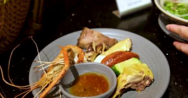 Cruiser 'da büyük bir balık yemeğinin servis edildiği açık büfe sahnesi. Balık, aşındırıcı bir tabağa konmuş sebze ve sosla süslenir. Bir insan balığı tabakta servis etmek için maşa kullanıyor..