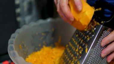 Aşçı kabağı tabakları hazırlamak için büyük bir rendelenmiş rende rendeliyor. Yakın plan. Yüksek kalite 4k görüntü