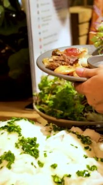 İnsanlar tabaklarına yemek koyar. Olay yerinde büfede açık büfe yemekleri. - Evet. Deniz ürünleri büfesi.