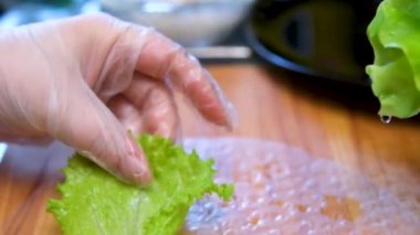 Mutfak konsepti, ev yapımı yemekler için hazırlama malzemeleri. Önlüklü genç bir kadın yemek pişiriyor, mutfak tezgahında sebzeli börek yapıyor. Ev yemeği ve gastronomi..