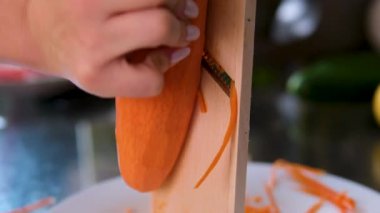 Salata yapmak için havuç rendele, detaylar. Demir rendesinin içine rendelenmiş havuçlarla bak. Yüksek kalite 4k görüntü