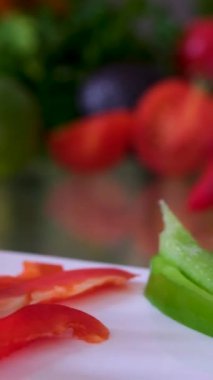 Ahşap tahtada taze dolmalık biber keserken bıçakla şefin ellerini yakın plan çek. Cooker kesme tahtasında biber kesmeye hazırlanıyor. Yeşil biberi bıçakla küçük parçalara ayır.