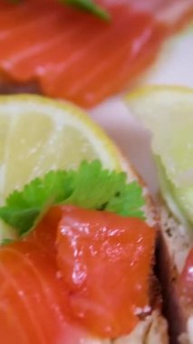 Yumuşak krem peynirli somon sandviçi, salatalık ve kekik, deniz mahsulleri tostu, stok video 4K. Yüksek kalite 