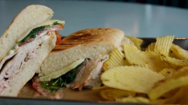 Kadın eli patates kızartması ve tavuklu sandviç yiyor.