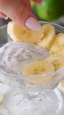 Chia tohumlu yoğurt taze olgun bir muz ekler. Muzlu yoğurt yapımında kullanılan taze muz parçaları. Yüksek kalite 4k görüntü