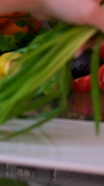 Kesme tahtasının üzerinde su damlaları olan yeşil soğan tüyleri, yakın çekim makro dönüşümlü çekim. - Evet. Yüksek kalite 4k görüntü