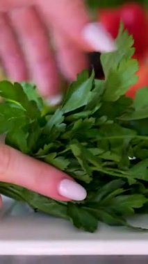 Şef yeşil ıspanak yapraklarını kesme tahtasının üzerinde bir bıçakla keser. Aşçı, kamera yavaşça hareket ederken ıspanağı yavaş çekimde doğruyor. Sebze salatası yapmak, sebzeli yemek yapmak, sağlıklı. 