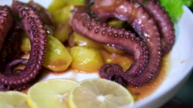 Beyaz bir tabakta patates ve soslu ahtapot parçası. Yüksek kalite 4k görüntü