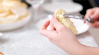 Kadın bir dilim ekmeğe yumuşak tereyağı sürüyor. Ekmeğe krem peynir sürüyorum. Ev hanımı kahvaltı için sandviç yapıyor. Yüksek kalite 4k görüntü