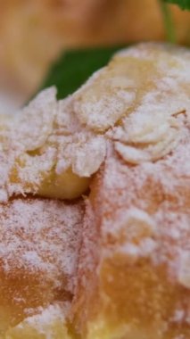 Bir kadın eli, badem yapraklarıyla kaplı bir kutu kruvasan açar. Pastanede tatlı, tatlı pasta. Yüksek kalite 4k görüntü