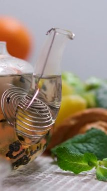 Çaydanlıktaki yeşil çayı ve beyaz tahta masadaki fincanı kapat. Yüksek kalite 4k görüntü