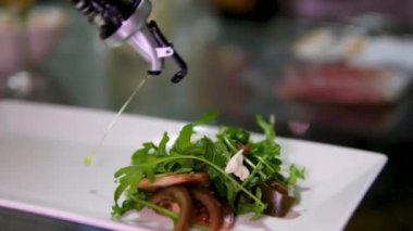 Ev mutfağında yemek hazırlıyorum. Kahvaltı hazırlamak ya da restoranda öğle yemeği. Fast food yakın plan. Erkek şef büyük sandviçin üzerine salatalık ve salatayla zeytinyağı döker. Sağlıklı gıda kavramı.