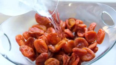 Kurutulmuş kayısıları akan suyun altında yıka. Olgun kayısı ağır çekimde durulanıyor. Yüksek kalite 4k görüntü