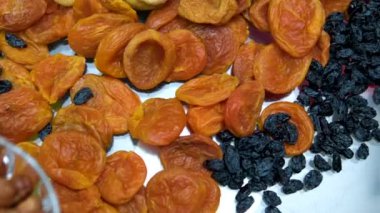 Ceviz, badem, fıstık, fıstık, kuru kayısı, kuru üzüm, fındık, kabak çekirdeği gibi çeşitli meyveler var. Dikey video. Sağlıklı gıda konsepti. Atıştırmalıklar. 