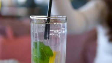 Taze yaz kokteyli yapıyorum. Buzlu bardağa karbonatlı su dökmek. Ağır çekim. limon ve limon dilimleri. Nane, ferahlatıcı soda tonik. Soğuk mojito limonata, köpüklü soda.