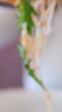 Kız bir dilim pizza alır ev yapımı pizza üzerine roka, domates dilimleri ve peynirle kaplanmış, pişirme malzemeleriyle çevrili. Yüksek kalite 4k görüntü