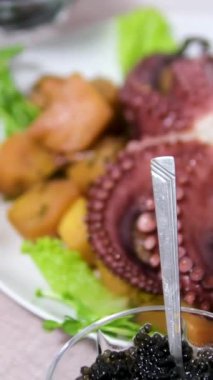 Bir restoranda bir ahtapot tabağı masaya konur. Garson tabağı getirir ve masaya koyar. Restoran menüsü. Yemek videosu. Restoranlar ve kafeler için video. Yüksek kalite 4k görüntü