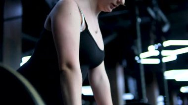 Beyaz spor ayakkabılı genç kız beden eğitimi dersinde adım adım kendini disipline sokma vücudunu şişirme hareketi yapıyor. Bir sınıftan birkaç video