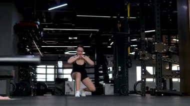 Beyaz spor ayakkabılı genç kız beden eğitimi dersinde adım adım kendini disipline sokma vücudunu şişirme hareketi yapıyor. Bir sınıftan birkaç video