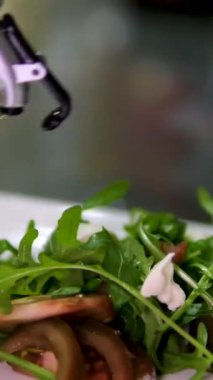 Ev mutfağında yemek hazırlıyorum. Kahvaltı hazırlamak ya da restoranda öğle yemeği. Fast food yakın plan. Erkek şef büyük sandviçin üzerine salatalık ve salatayla zeytinyağı döker. Sağlıklı gıda kavramı.