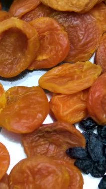 Ceviz, badem, fıstık, fıstık, kuru kayısı, kuru üzüm, fındık, kabak çekirdeği gibi çeşitli meyveler var. Dikey video. Sağlıklı gıda konsepti. Atıştırmalıklar. 