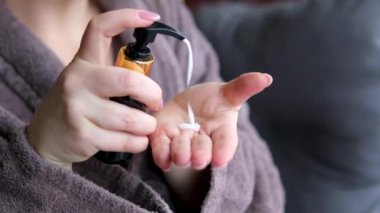 Cilt bakımı, hijyen ve sağlıklı yaşam konsepti. Kapatın. Banyoda yıkanmak, gelişmiş cilt bakımı için yumuşak jel kullanmak. Kadın elleri pompa plastik losyon şişesini itiyor ellerine nemlendirici krem sürüyor.