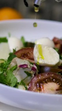 Farklı tabaklara yakın çekim zeytinyağı dökülüyor. Yemek pişirmek için mi yoksa salata sosu olarak mı kullanılıyor? Zeytinyağı yemek ve salatalar için popüler bir ek maddedir. - Evet. Yüksek kalite 4k görüntü