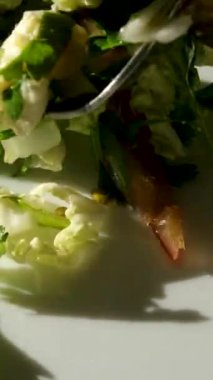 Büyük yeşil kase sağlıklı sebze salatası. Ağır çekim. Gölgeler. Domates, ahşap masa.