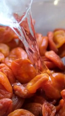 Kurutulmuş kayısıları akan suyun altında yıka. Olgun kayısı ağır çekimde durulanıyor. Yüksek kalite 4k görüntü