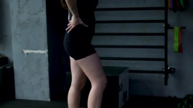 İnce vücutlu genç bir kadın spor salonunda egzersiz yaptıktan sonra belini ölçüyor, kız kilo veriyor, kalori yakıyor, spor yapıyor ve diyet yapıyor., 