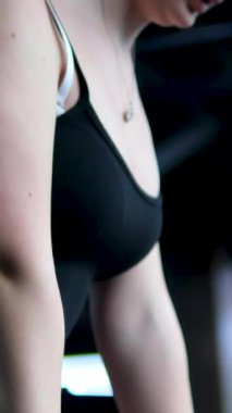 Beyaz spor ayakkabılı genç kız beden eğitimi dersinde adım adım kendini disipline sokma vücudunu şişirme hareketi yapıyor. Bir sınıftan birkaç video