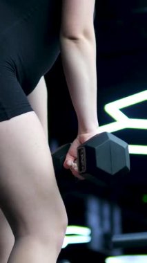 Beyaz spor ayakkabılı genç kız beden eğitimi dersinde adım adım kendini disipline sokma vücudunu şişirme hareketi yapıyor. Bir sınıftan birkaç video