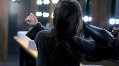 Bornozlu esmer kadın saç kurutma makinesiyle şarkı söyleyip dans ediyor ve aynaya bakıyor. - Evet. Yüksek kalite 4k görüntü