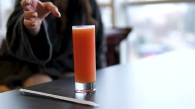 Portakal suyunu cama dökmenin çok yavaş bir yolu. Mutfak içiyle birlikte beyaz masaya yerleştirilmiş. Yüksek hızlı sinema kamerasıyla çekilmiş.