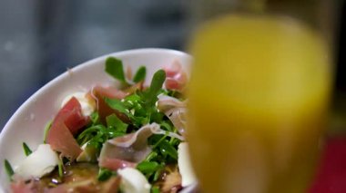 İtalyan jambonlu bresaola, roka ve parmesan peynirli tabak. Bir bardak portakal suyu.