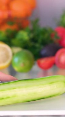 yeşil salatalıklar mutfakta bıçakla kesilir. Sağlıklı sebze salatası konsepti. Mutfaktaki yeşil salatalıklar yakın plan yaşam tarzını dilimlere ayırıyor. Yüksek kalite 4k görüntü