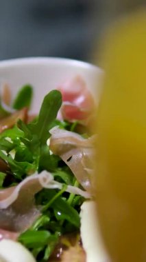 İtalyan jambonlu bresaola, roka ve parmesan peynirli tabak. Bir bardak portakal suyu.