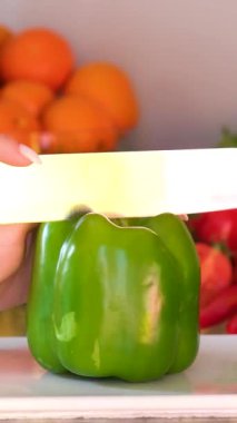 Yeşil biber kesiyorum. Ahşap tahtada bıçakla yeşil biber kesen şef. Kadın karabiberi küp küp doğradı. Sağlıklı, yeşil yemek. Sebzeleri salataya hazırlıyorum. - Evet. Yüksek kalite 4k görüntü