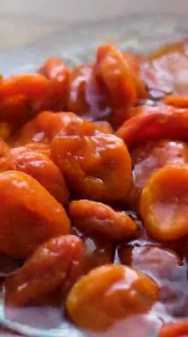 Kurutulmuş kayısılar yükselir ve düşer. Mavi arka planda. Film, yavaş çekim 1000 fp. Yüksek kalite 4k görüntü