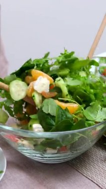 Sağlıklı yemek ve diyet için taze sebze salatası. Salatalık, salatalık ve soğandan oluşan taze bir salatanın içine zeytin yağı dökülüyor. Vejetaryen sağlıklı yiyecekler Akdeniz diyetinin temelidir.. 