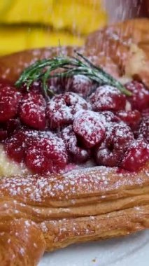 Elmalı taze pişmiş güzel puf börekleri ahşap bir masanın üzerine pudra şekeri serpiştirilir. Elmalı tatlı. Ev yapımı mis kokulu hamur işleri. Yakın plan, kamera aşağıdan yukarıya hareket ediyor.