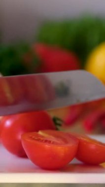 Ahşap tahtada bıçakla taze bir domatesi kesen şefin ellerini yakın plan çek. Mutfakta vejetaryen salatası hazırlayan fırıncı, 4K görüntü. Yüksek kalite 4k görüntü