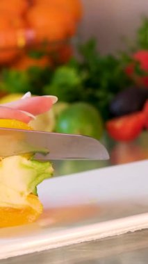 Ahşap kesme tahtasına sarı biber kesen beyaz kadın videosunu kapat. Yüksek kalite 4k görüntü