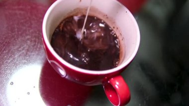 Yavaş çekimde çikolatalı sütü beyaz arka planda bardağa boşalt. Kaynar kakao.