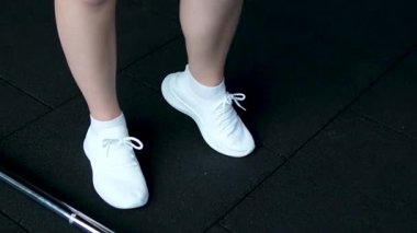 Kalça eklemi, bacağın eklem hareketi. Beyaz ayakkabılı kızın ayak bileği ve kalça eklemleri çıkıyor.