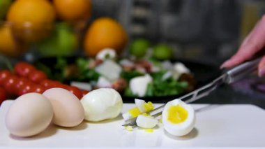 Bir şefin elleri mutfakta bir kesme tahtasının üzerinde haşlanmış yumurta doğruyor. Yüksek kalite 4k görüntü