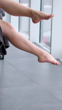 Kadın, tropikal bir adada, ayakları havada ve arka planda güzel bir kış penceresi manzarası olan rahatlatıcı bir anın tadını çıkarıyor. Yüksek kalite 4k görüntü