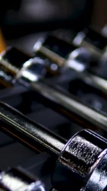 Kapalı spor salonunun arka planında parlak metalik halterler var. Yüksek kalite 4k görüntü