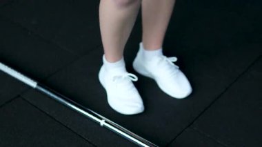 Kadın koşu bandında ayak bileğini uzatıyor. Sporcu kadın antrenman makinesinde koşmadan önce bacak ısıtması yapıyor. Uygun spor hazırlığı. Yüksek kalite 4k görüntü